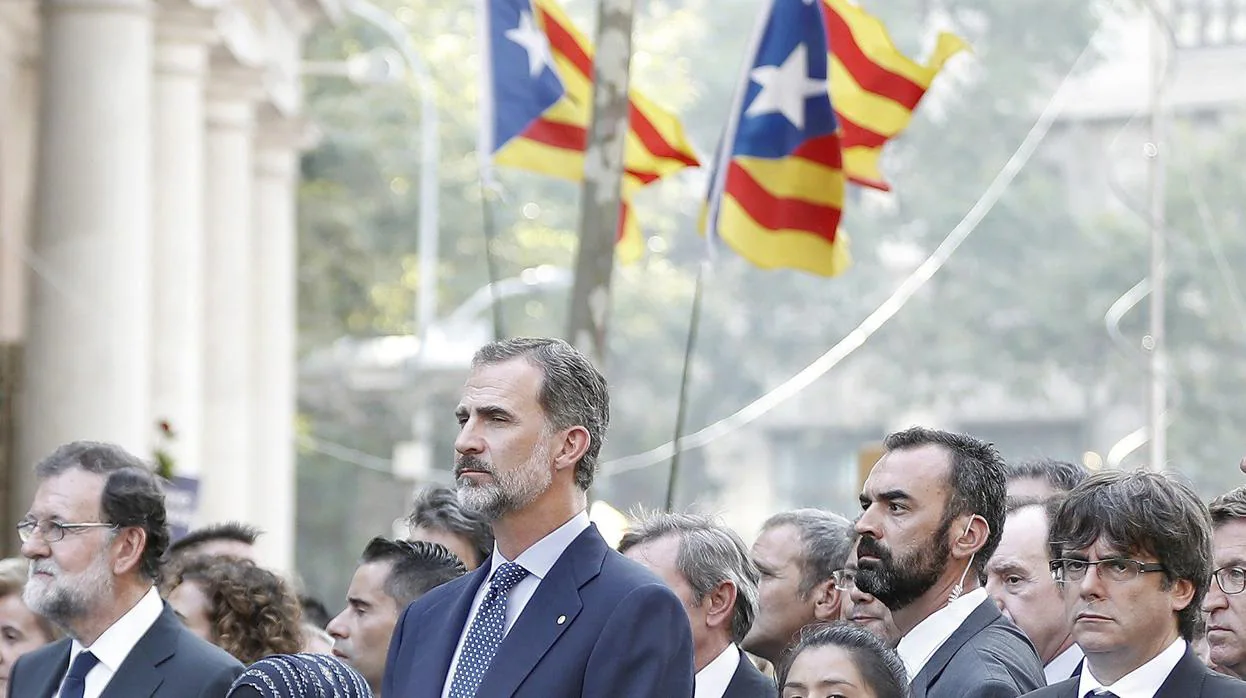 El Rey Felipe VI, junto a los expresidentes del Gobierno, Mariano Rajoy, y de la Generalitat, Carles Puigdemont, en Barcelona tras los atentados de agosto