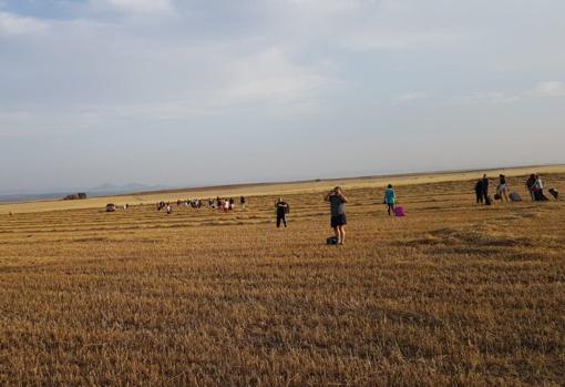 Viajeros apeados del tren andando por el campo