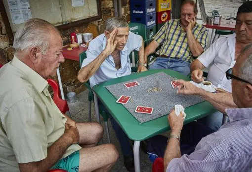 Un grupo de jubilados juega a las cartas en Aoslos, donde aún predomina la ganadería como actividad principal