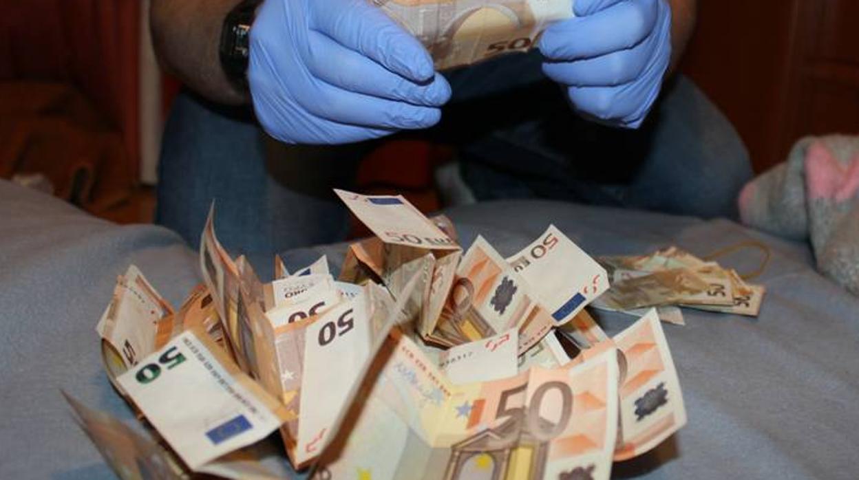 Un agente de la Guardia Civil, en el recuento de uno de los fajos de billetes intervenidos