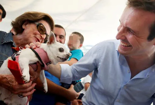 Pablo Casado saluda a una señora y a su perro en un acto en Alicante