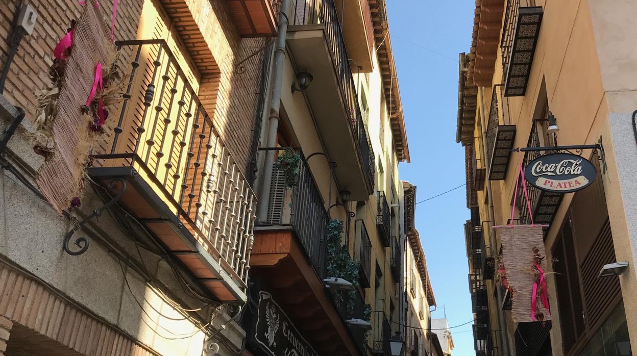 En la calle Tornerías aún están colgados tiestos y adornos con lazos rosas