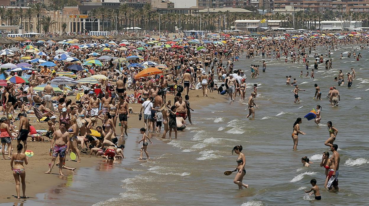 Imagen de una plenitud de gente refrescándose en la playa de La Malvarrosa