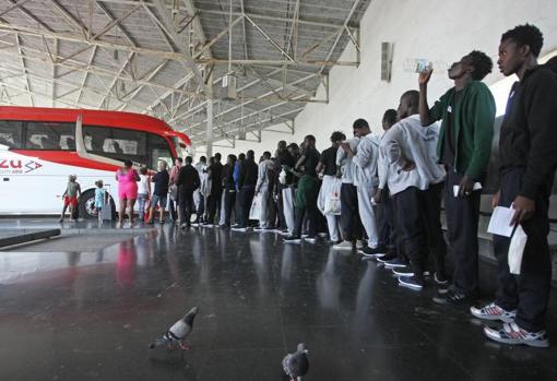 Decenas de inmigrantes antes de subir a un autobús en la estación de Algeciras