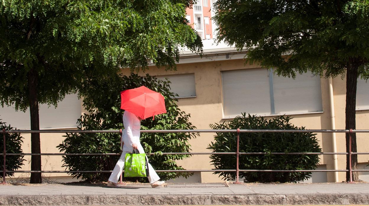 Una mujer se protege del sol con un paraguas en Orense