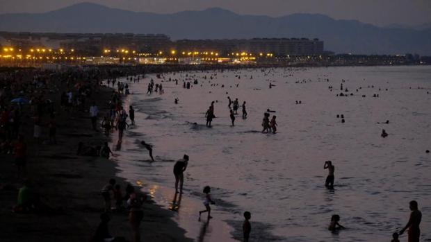 Ola de calor en Valencia: muchos bañistas de noche y familias cenando a la fresca en el paseo marítimo