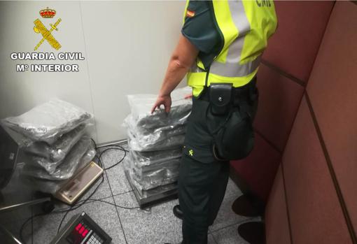 Un agente de la Guardia Civil inspeccionando la droga