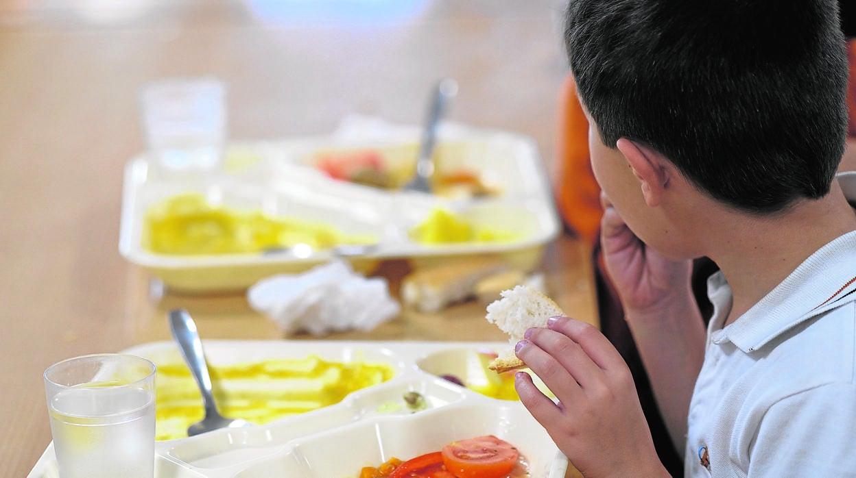 Un niño come su almuerzo en un comedor escolar