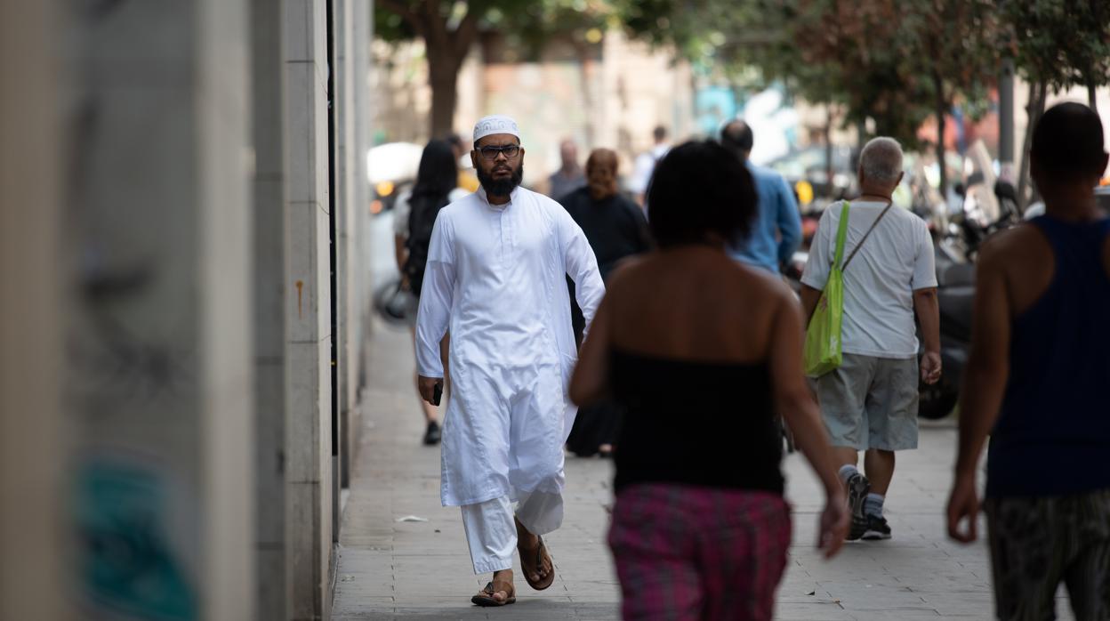 Un inmigrante pasea por las calles de la Raval
