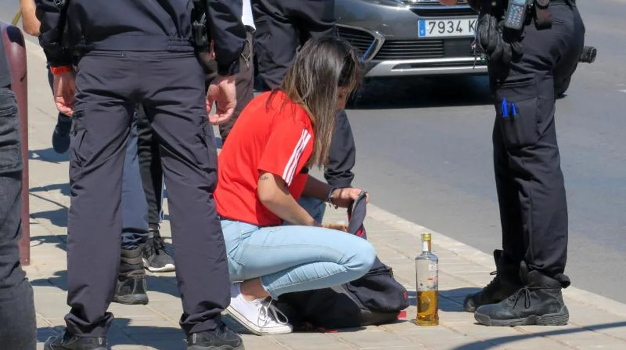 Una patrulla policial junto a una joven que practicaba botellón en Alicante