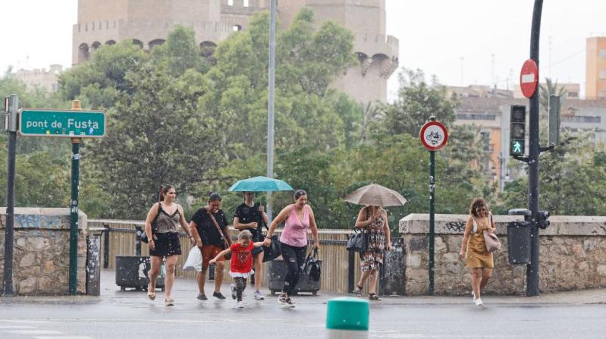 Transeúntes se protegen de la lluvia este lunes en Valencia