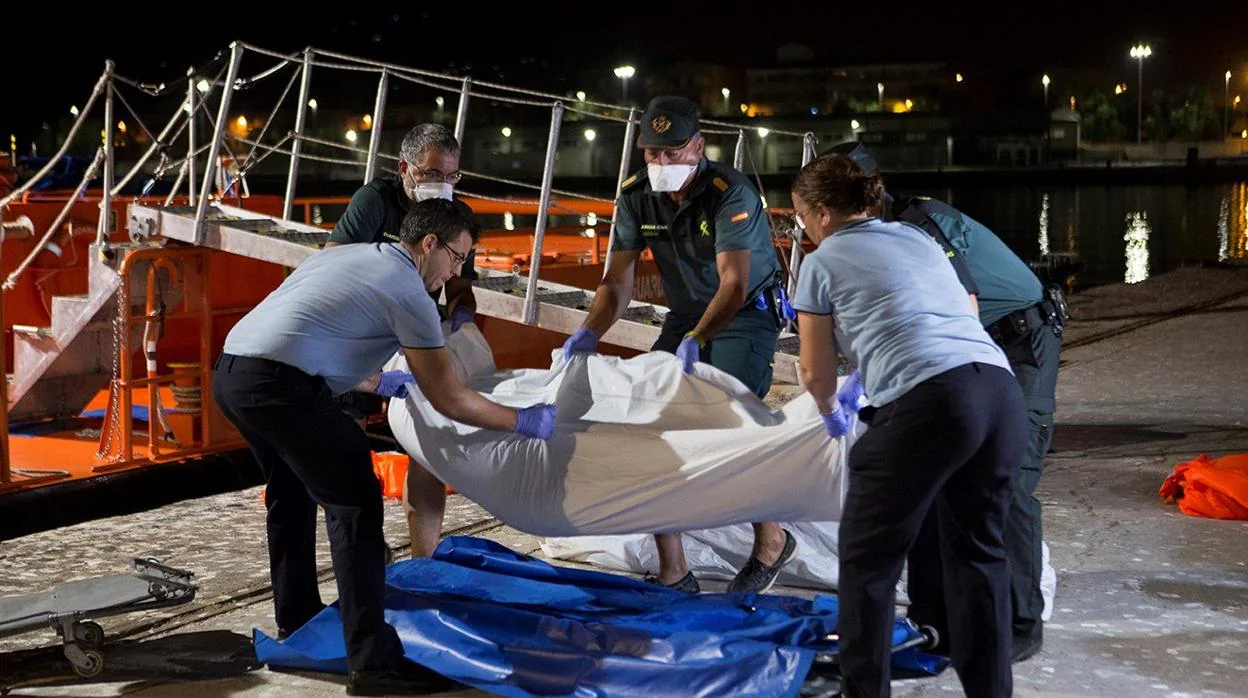 La Guardia Civil posa los cadáveres de los inmigrantes en el suelo a la llegada al puerto