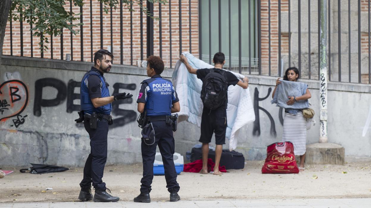 Una pareja de gitanos búlgaros, recogiendo sus bártulos ante la Policía Municipal