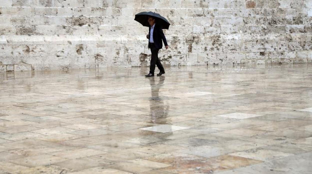 Un hombre pasea por el casco antiguo de Valencia bajo la lluvia