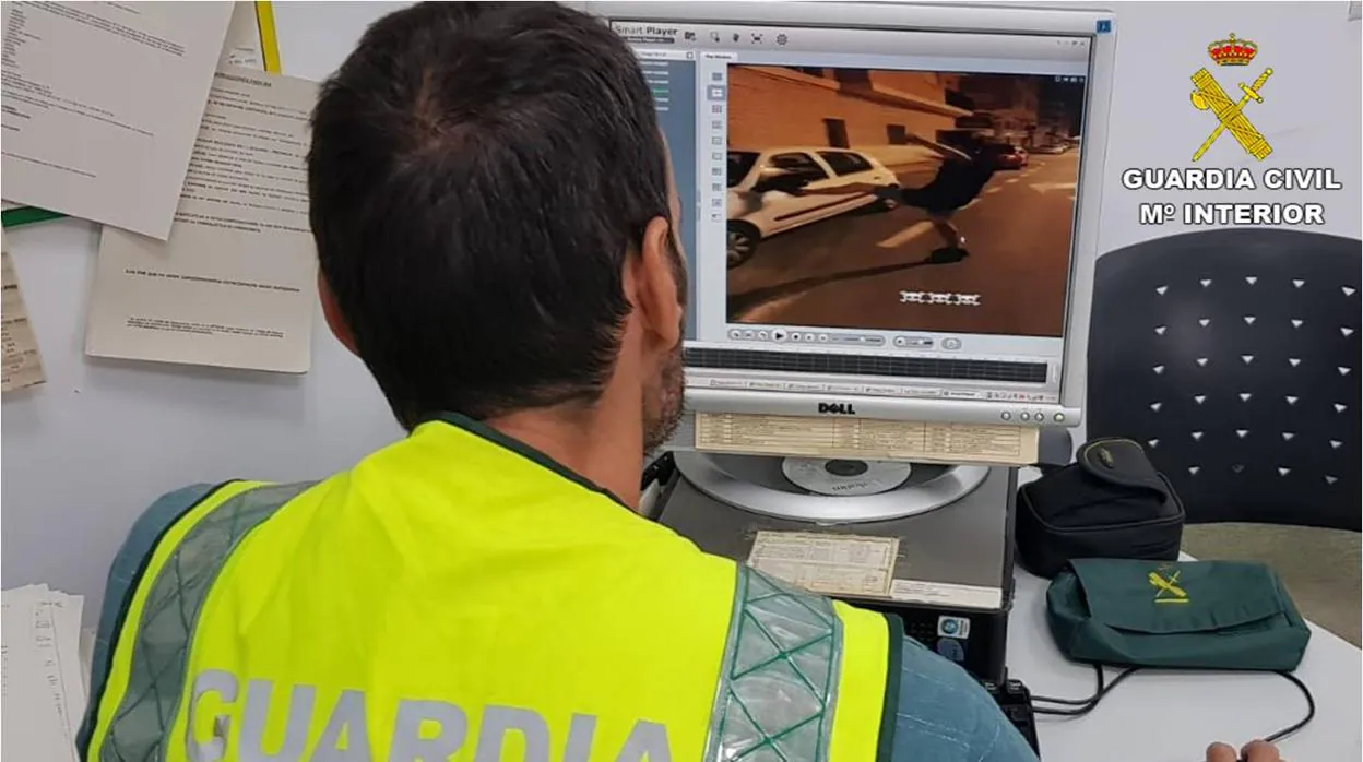 Un agente de la Guardia Civil observa a un joven pateando un coche en uno de los vídeos difundidos en redes sociales