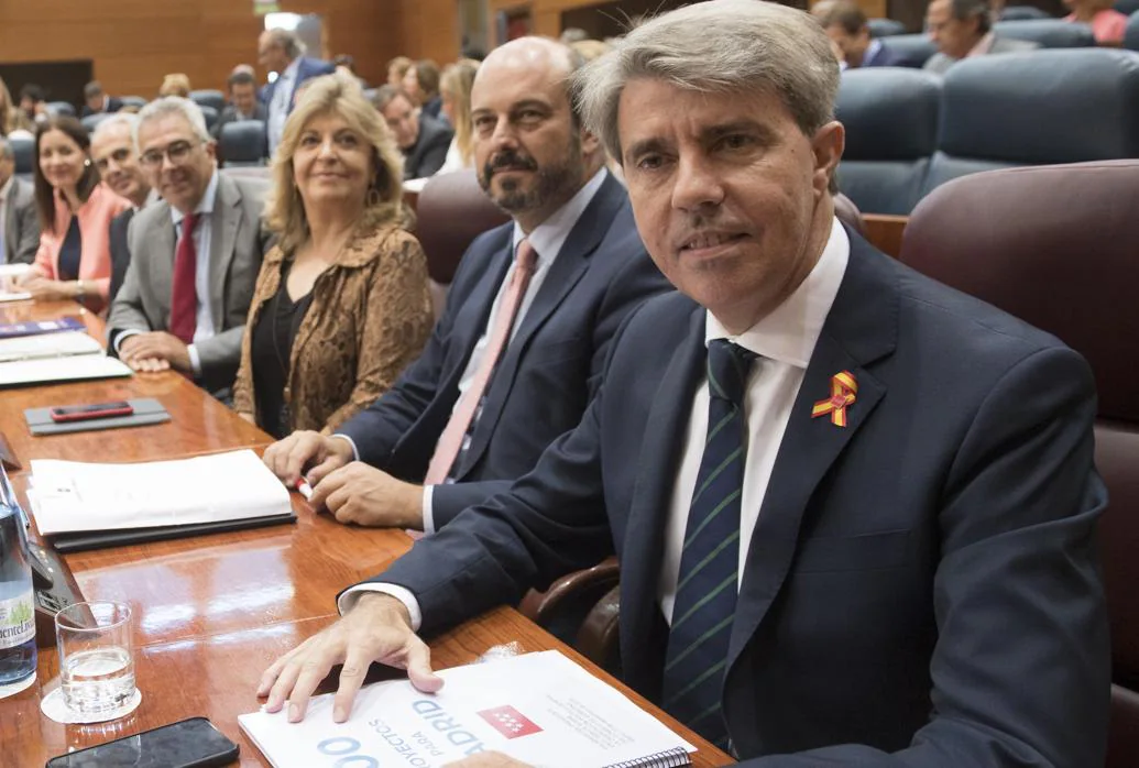 Ángel Garrido, presidente regional, porta un lazo con la bandera de España durante el debate del estado de la región