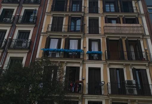 Balcones adornados con lazos azules en un edificio del barrio de Lavapiés