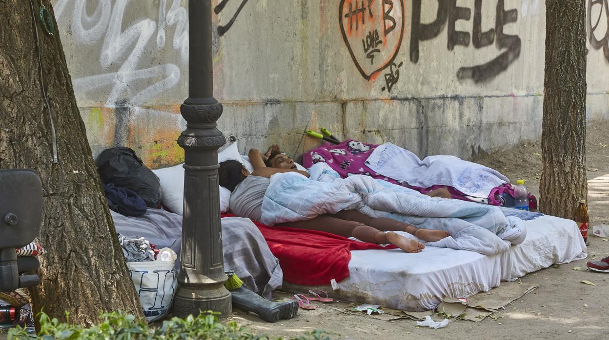 Mendigos, durmiendo sobre colchones en una calle del distrito Centro
