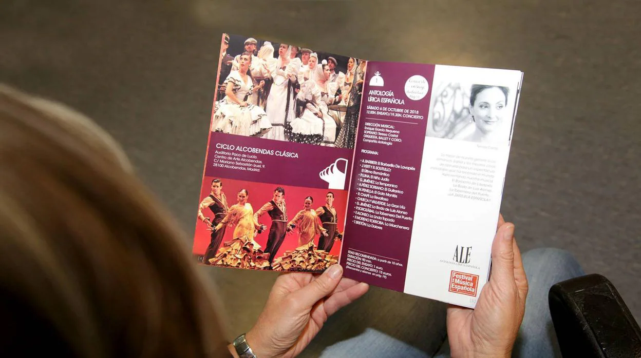 Una mujer revisa el programa del festival de música española en Alcobendas