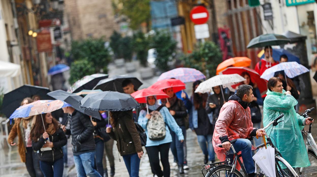 Un grupo de personas se protege de la lluvia en Valencia en una imagen de archivo