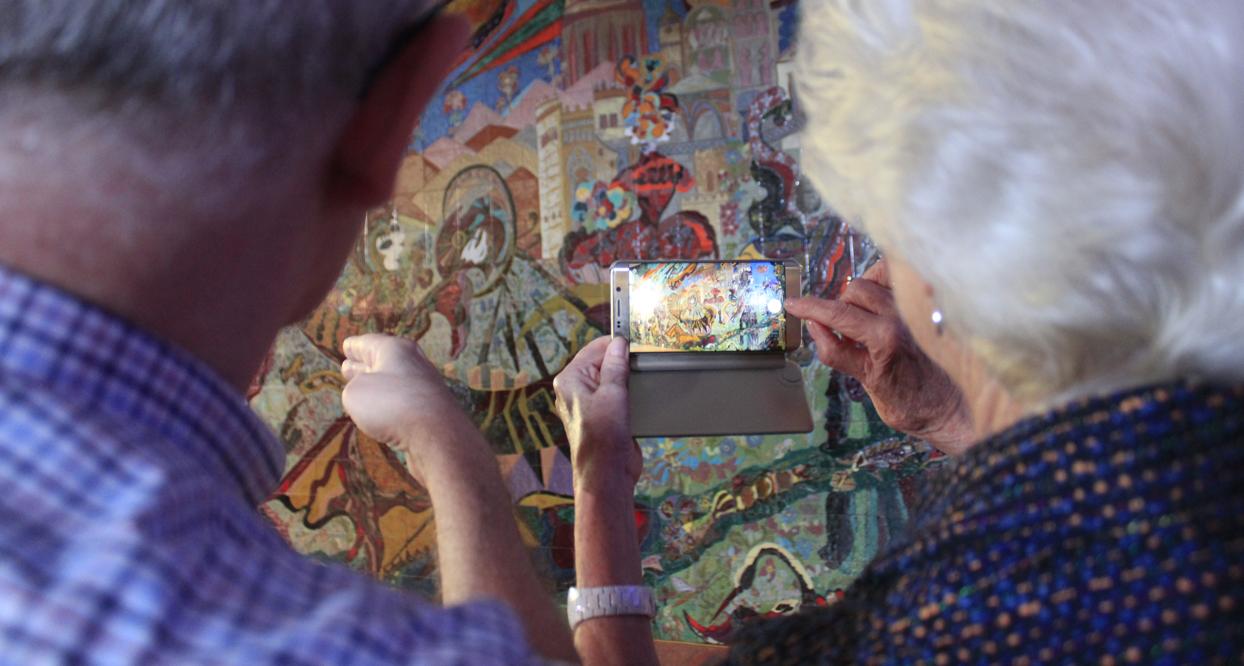 Dos asistentes fotografían el mural