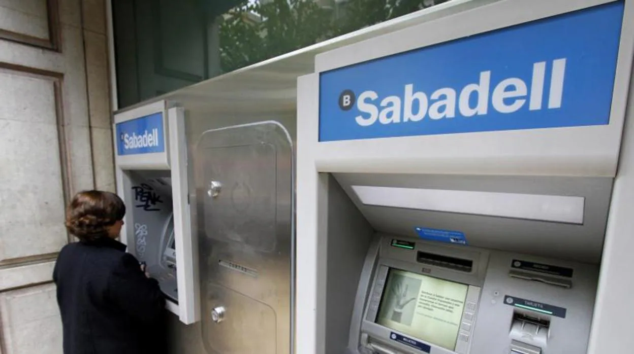 Una mujer retira dinero en un cajero del Banco Sabadell