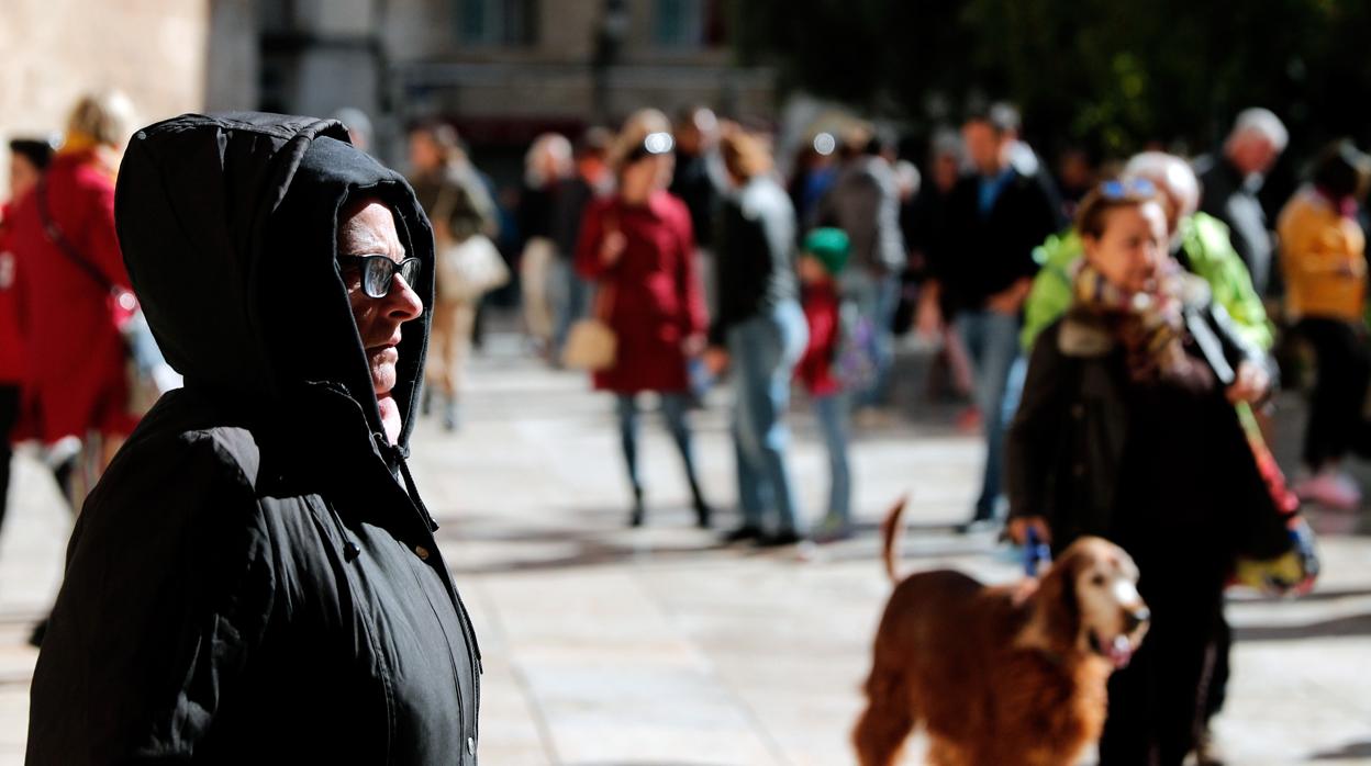 Una mujer se protege del frío en una imagen captada en el centro de Valencia