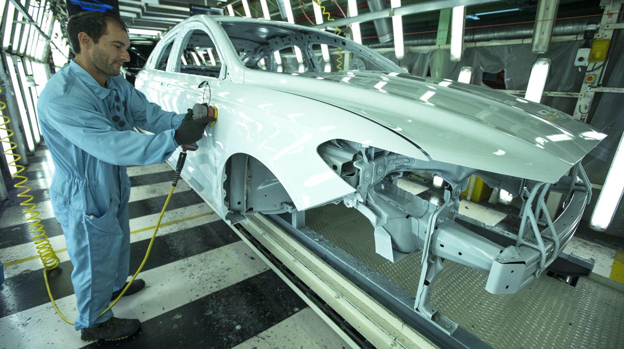 Un trabajador de la planta de pintura de Ford en Almussafes (Valencia) revisa una carrocería