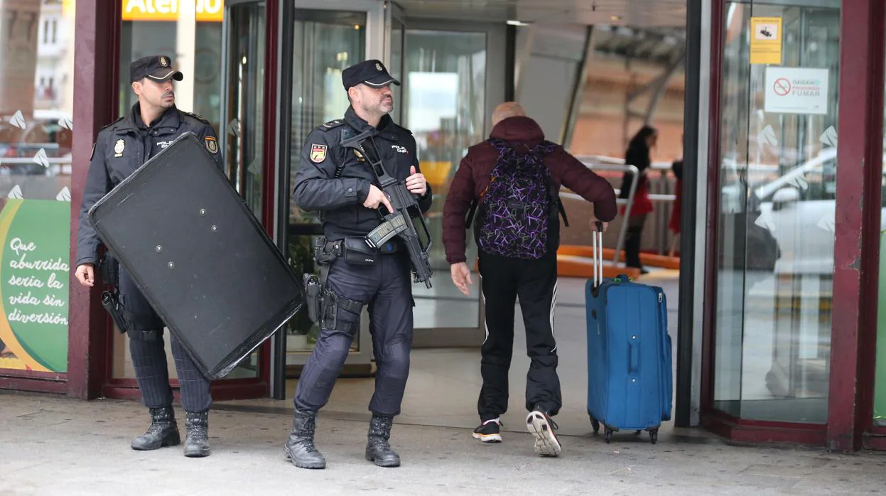 Dos policías armados junto a un viajero en la estación de Atocha