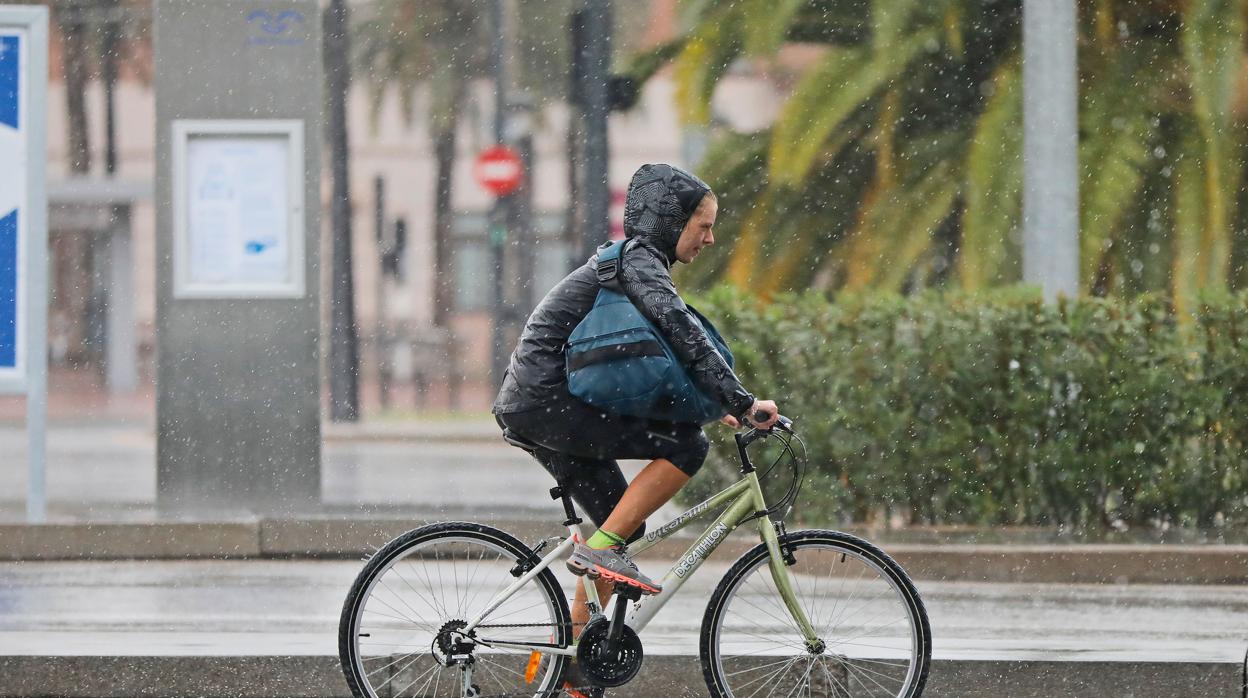 Imagen de archivo de un ciclista circulando bajo la lluvia en Valencia