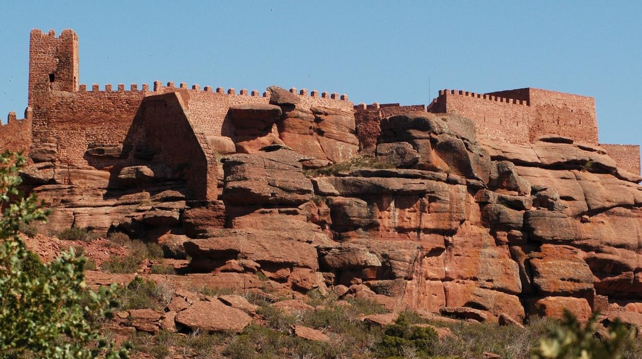 Silueta del castillo de Peracense, mimetizado con la rojiza mole de roca sobre la que se asienta