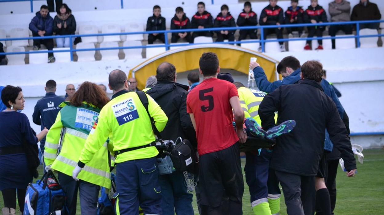 Momento en el que las asitencias médicas retiran del campo a Álex Duran, del CD Caudetano