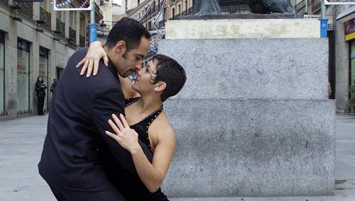 Dos personas bailan un tango delante de la estatua de El Oso y el Madroño