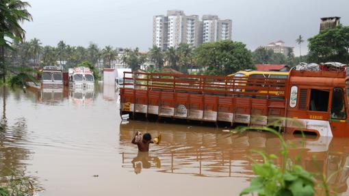 Un hombre cruza una avenida inundada en Kochi, estado de Kerala