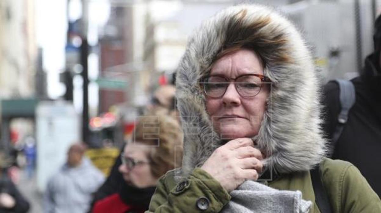 Dos mujeres abrigadas se protegen de los efectos del frio