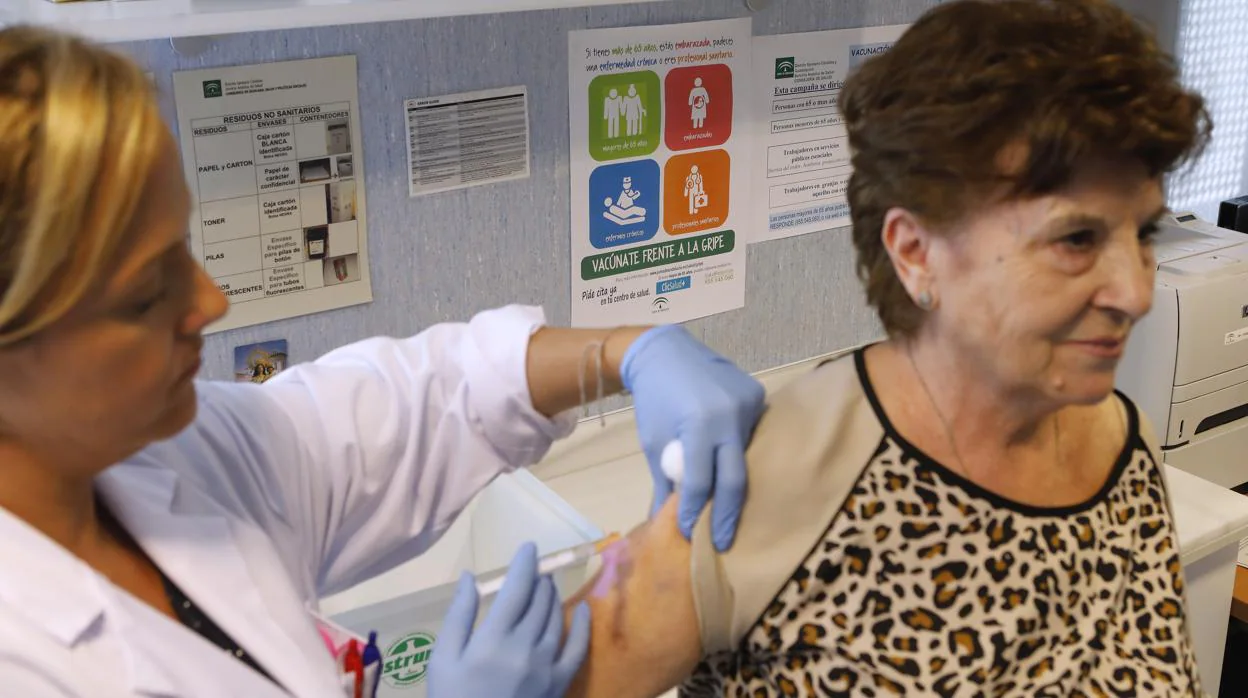 Una mujer recibe la vacuna de la gripe