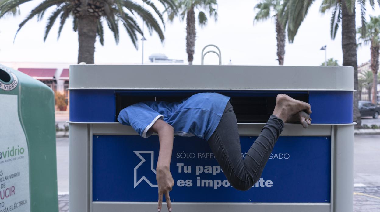 Un menor entrando en un contenedor de papel en Melilla