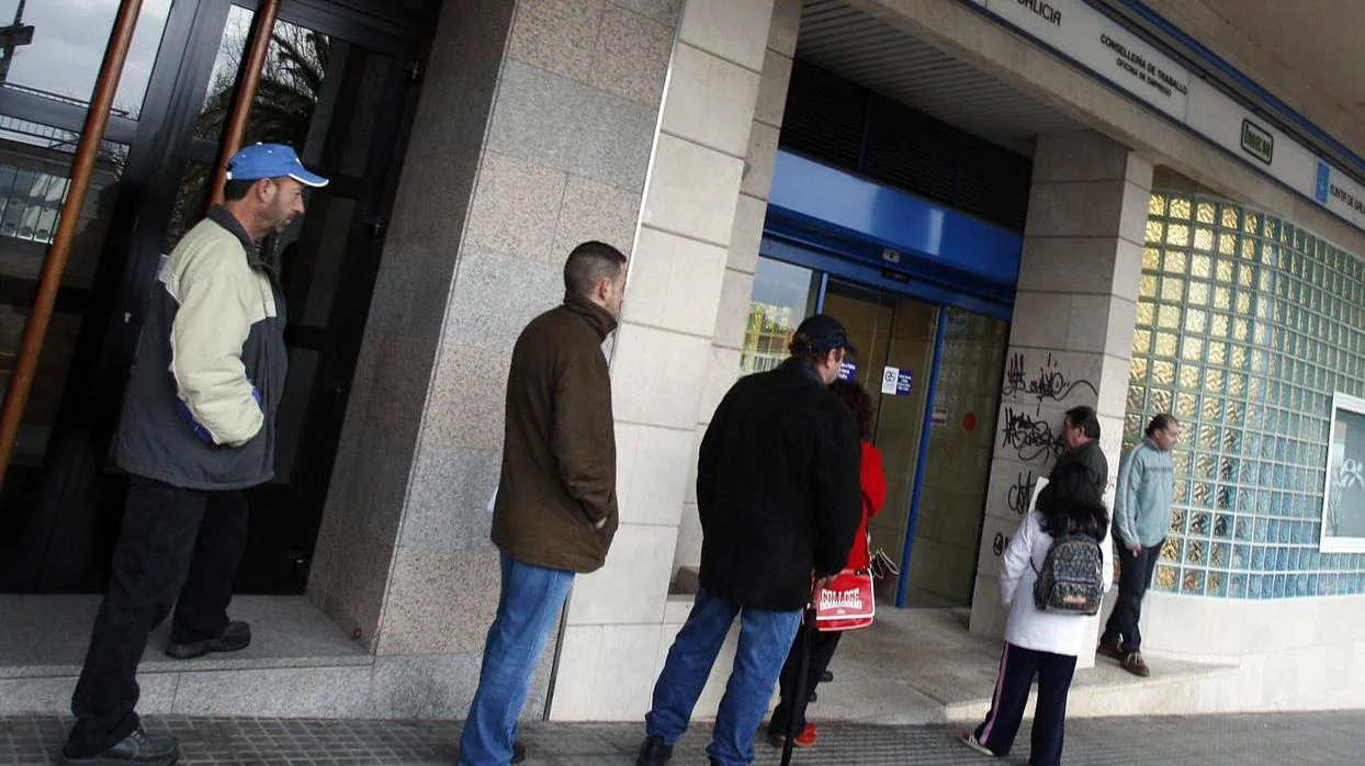 Un grupo de personas espera a las puertas de las Oficinas de Empleo en Santiago