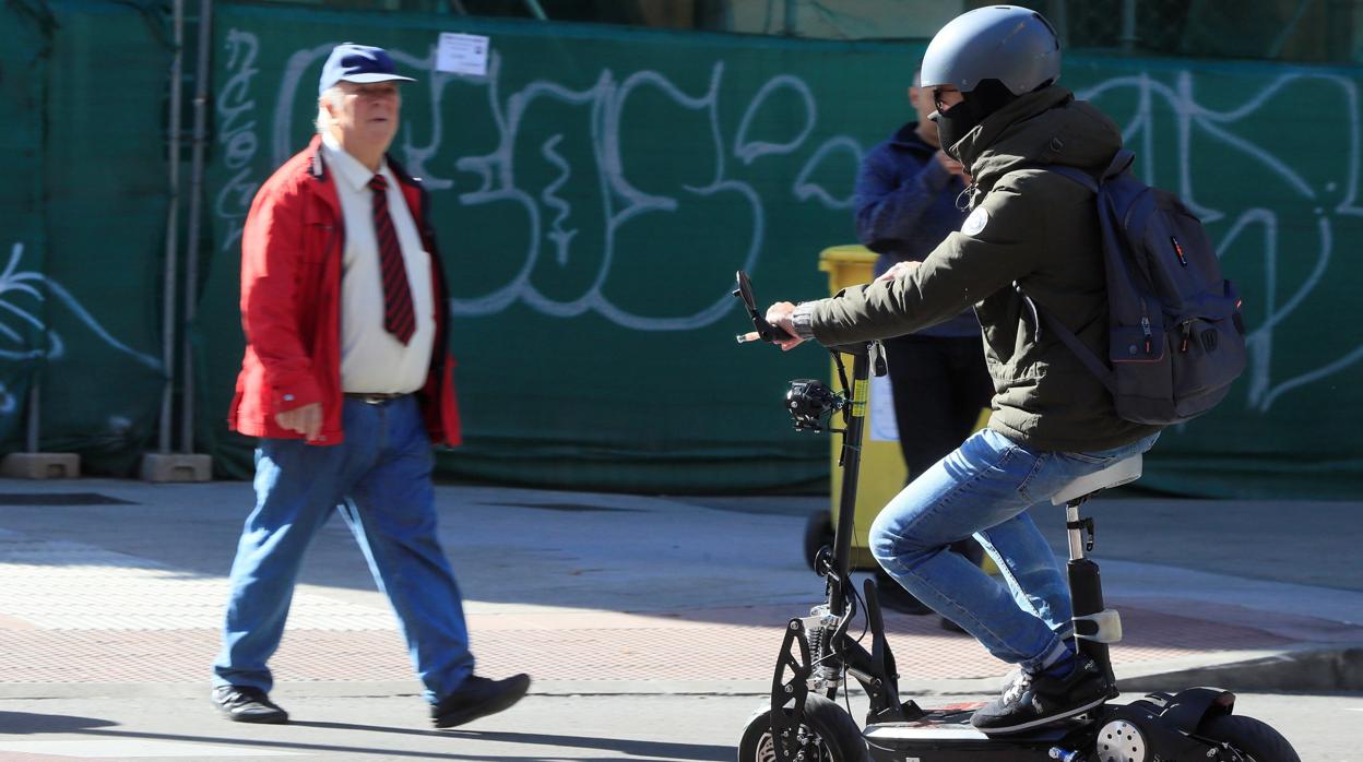 Un hombre circula con un patinete eléctrico, en una foto de archivo