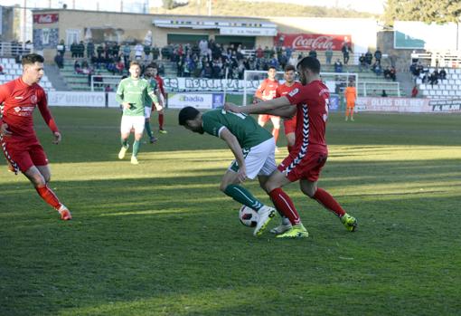 El delantero del Toledo Manu Gavilán sufre el acoso de Miguel Pérez