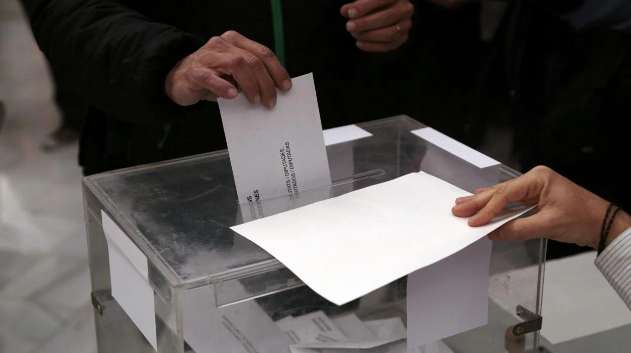 Un votante deposita su papeleta en una urna