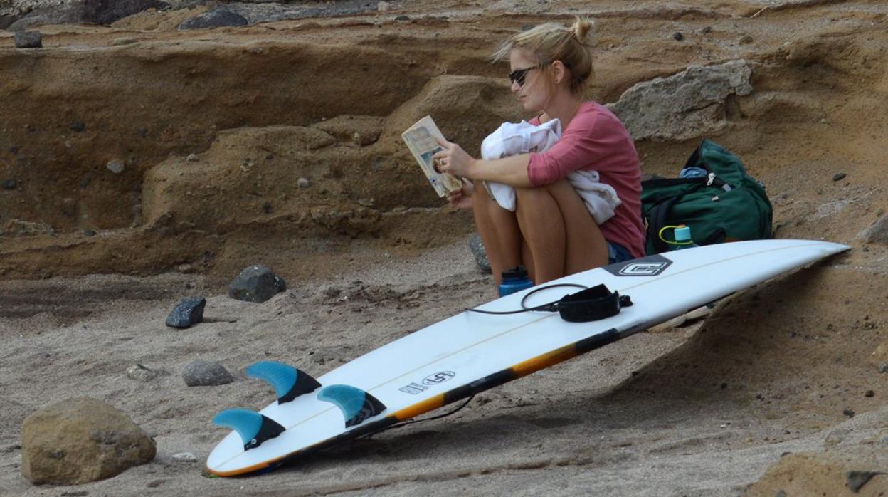 Una turista leyendo en Playa de El Confital, islas Canarias