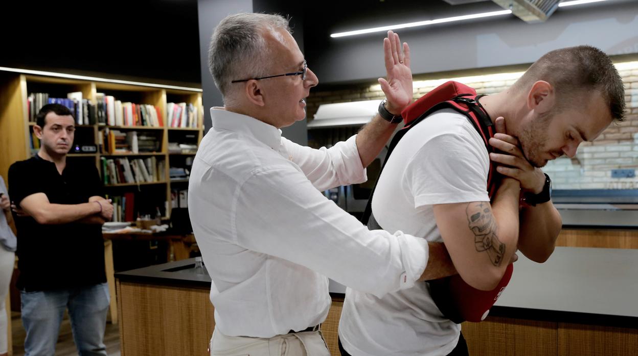 Un hombre practicando una maniobra sobre otro en un simulacro de atragantamiento