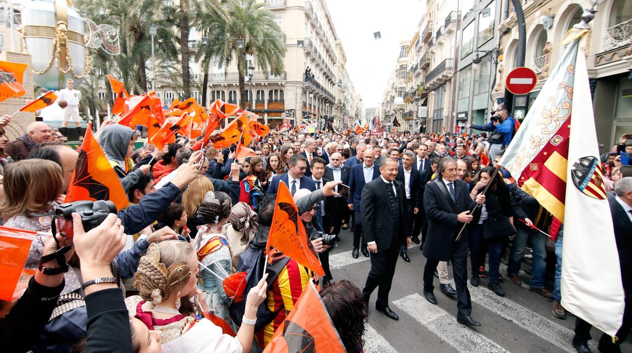 El exjugador del Valencia CF, Ricardo Arias (d) acompañado por el presidente del club, Anil Murthy, portando la bandera del club durante la marcha cívica que ha congregado a miles de aficionados el centenario de su fundación