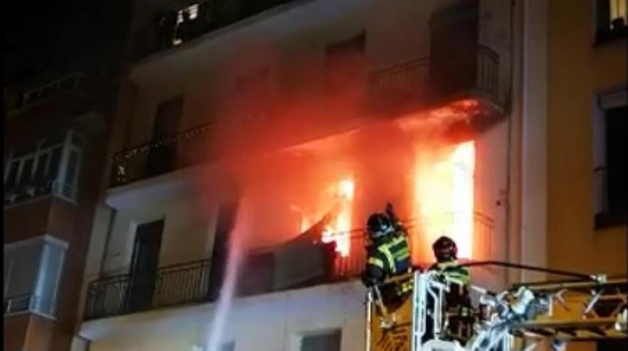 Los bomberos tratan de extinguir las llamas del incendio que rompe por la fachada