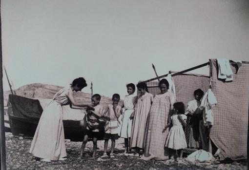 Una familia se prepara con la indumentaria para los baños de sol o de agua marina junto a las casetas de baño en la primera década del siglo XX