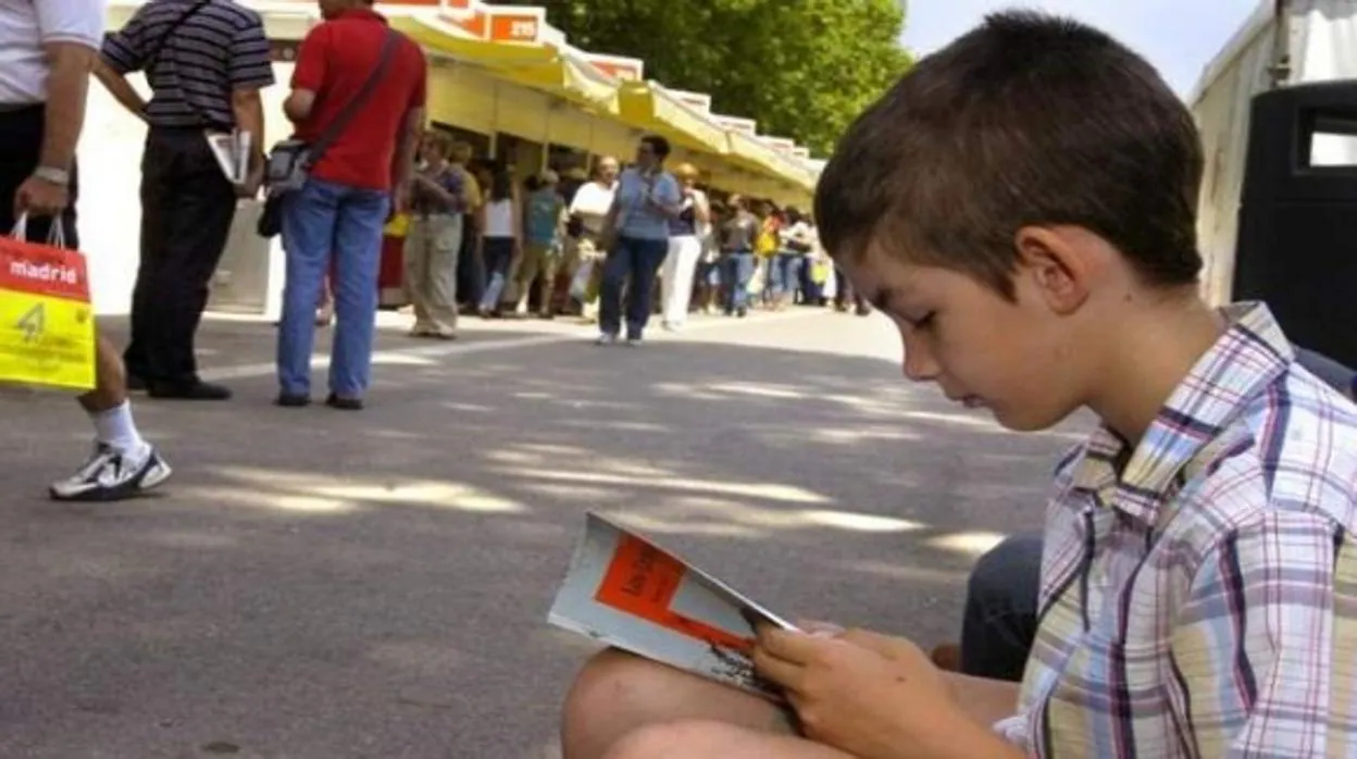 Un niño leyendo en la Feria del Libro