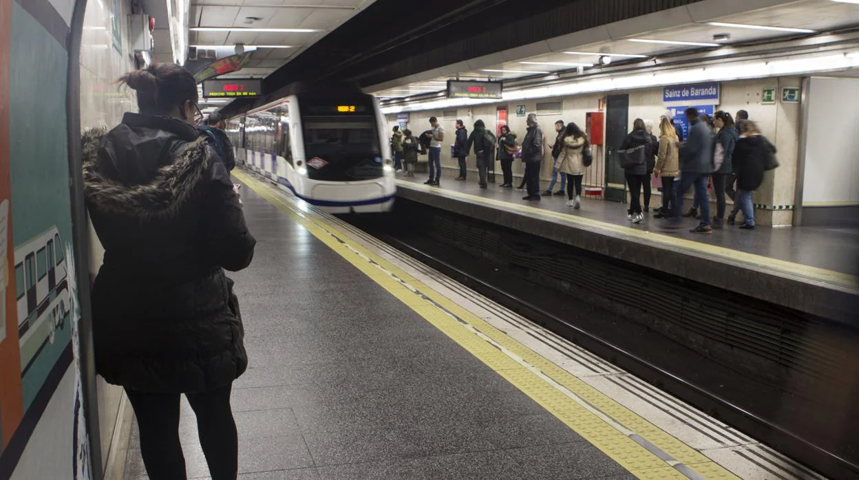 Viajeros esperan la llegada del Metro en una estación madrileña