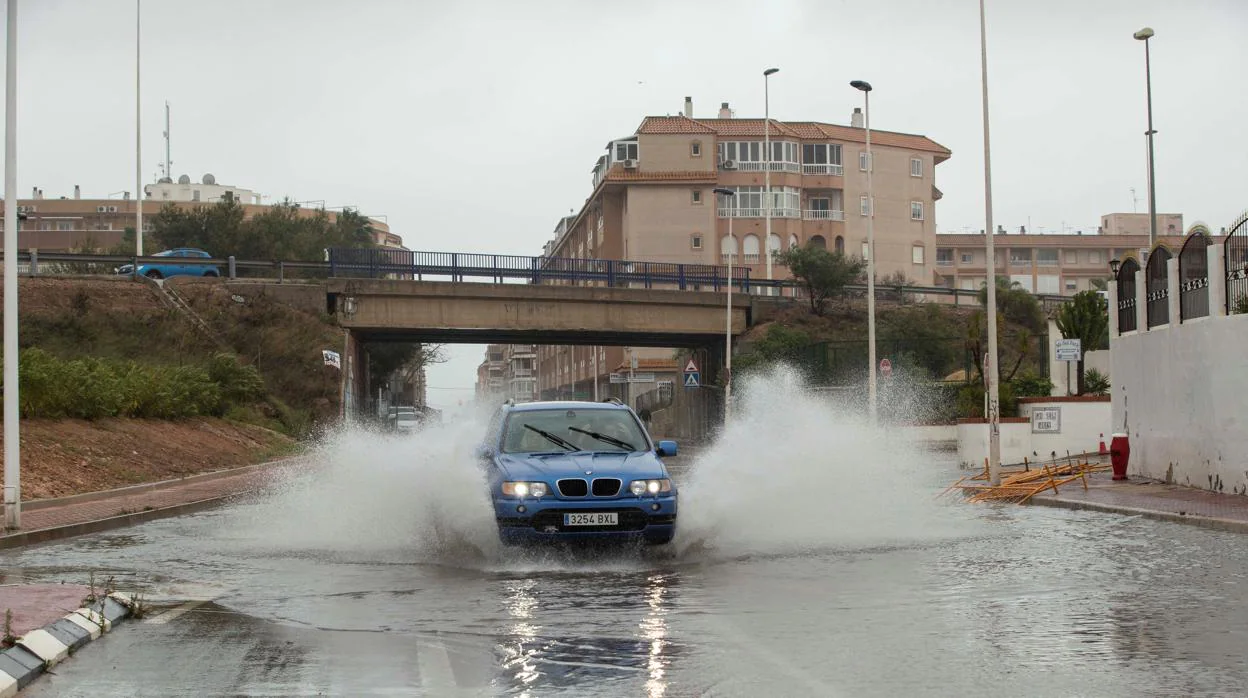 Un vehículo circula esta mañana por una calle inundada en la zona del Parque de las Naciones de Torrevieja (Alicante)