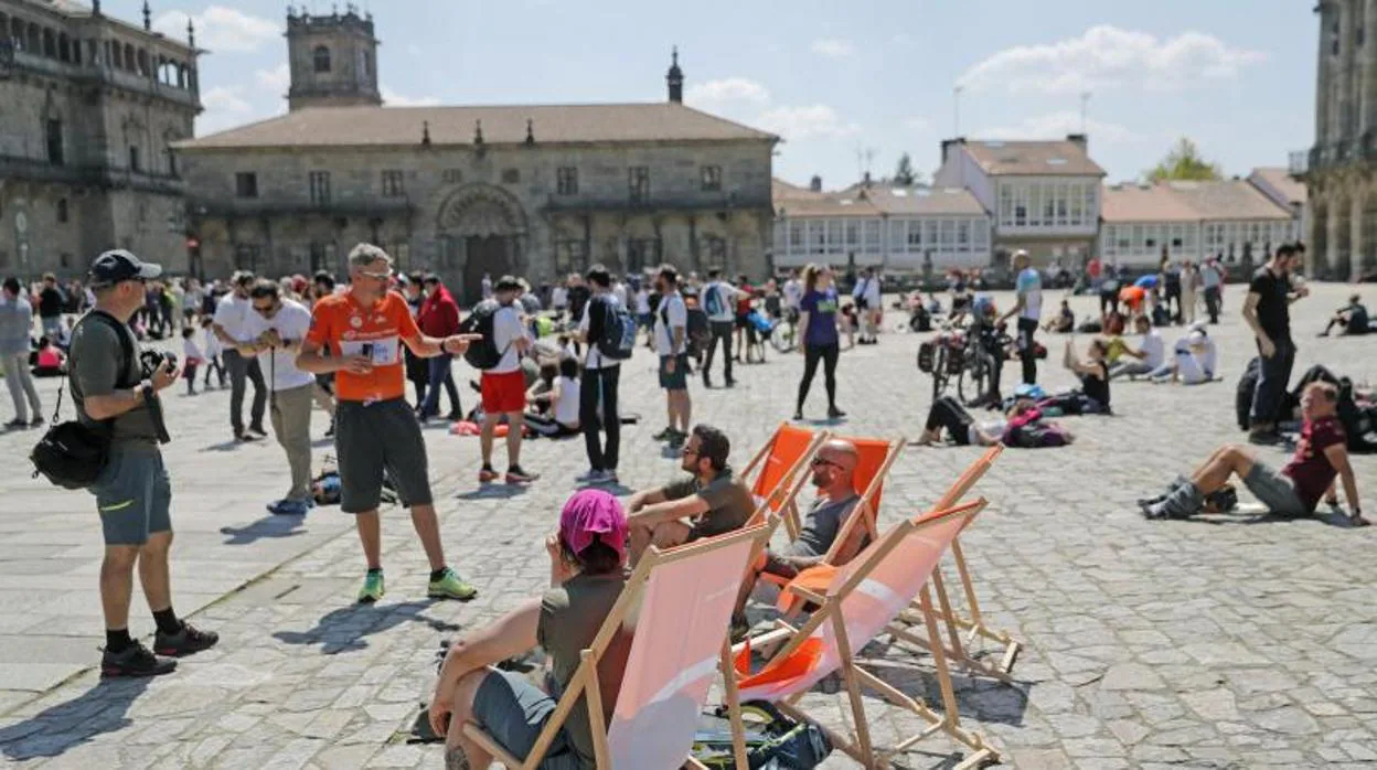 Peregrnos en la plaza del Obradoiro disfrutando de la jornada soleada de este domingo